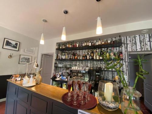 a bar with a large shelf of alcohol bottles at Auberge du Chasseur in Grosrouvre