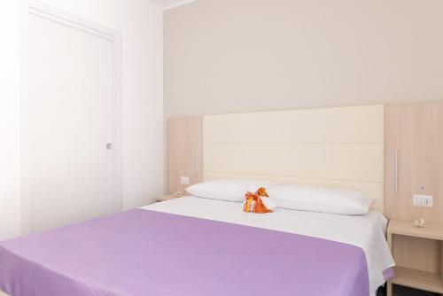 a bedroom with a large bed with a purple blanket at B&B Stern in Porto San Giorgio