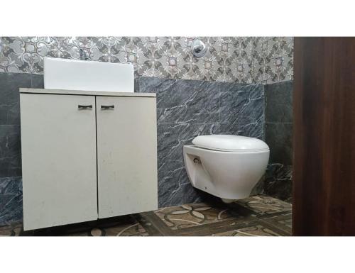 a bathroom with a white toilet and a cabinet at Hotel sai deogar in Deoghar
