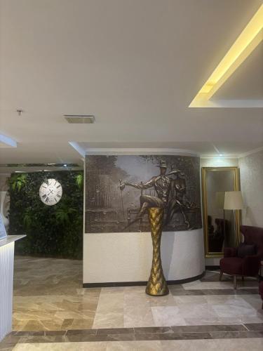 a statue in a room with a painting and a clock at Boris Hotel Beylikdüzü in Beylikduzu