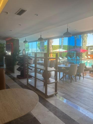 a dining room with tables and chairs and windows at Boris Hotel Beylikdüzü in Beylikduzu