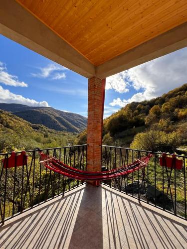 a porch with a hammock on a balcony at sharakhevi guesthouse 