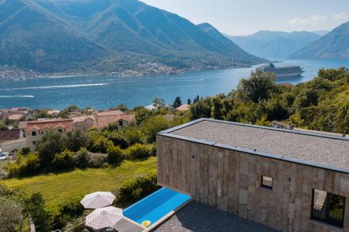 a building with a view of a body of water at Villa Invicta with 17m pool and bay view in Kotor