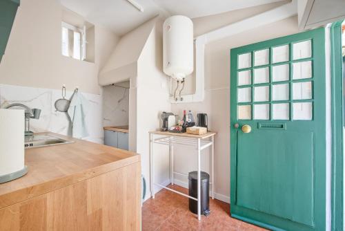 a green door in a kitchen with a counter at Pateo do Tempo in Carcavelos