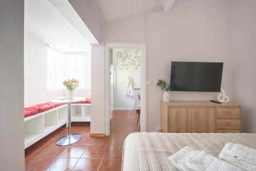 a bedroom with a bed and a flat screen tv at Pateo do Tempo in Carcavelos