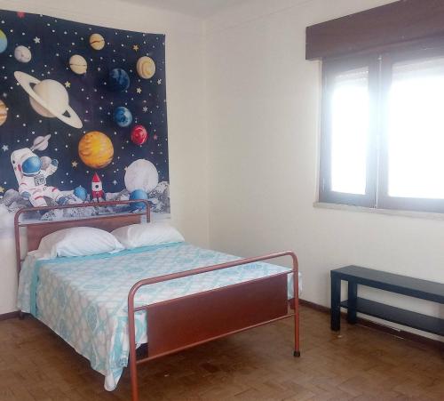 a bedroom with a bed with a painting of planets at Lisbon Private Room near airport in Lisbon