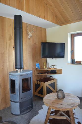 a living room with a wood stove and a table at De Hipshoek in Poperinge