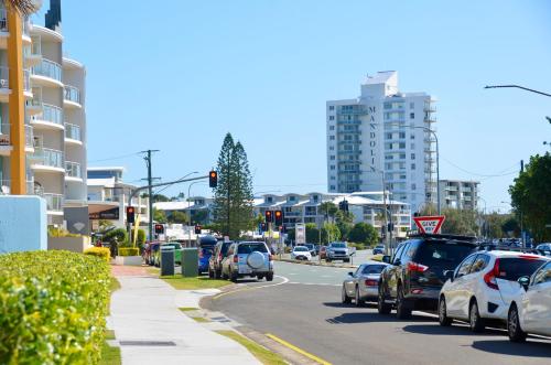 a busy city street with cars stopped at a traffic light at Alex Beach Apartment in Alexandra Headland
