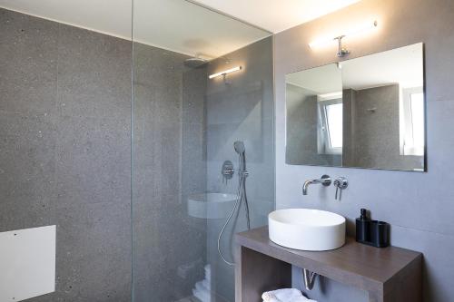 a bathroom with a sink and a glass shower at Lofos Panorama Apartments in Prínos