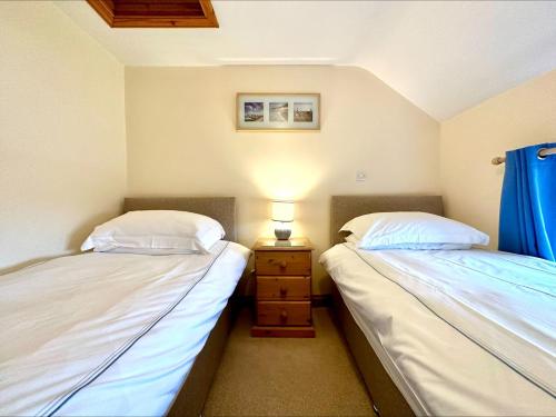 two beds sitting next to each other in a bedroom at 3 Bed in Clovelly TREET in Woolfardisworthy