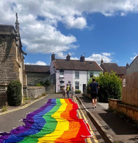 a rainbow colored street with people walking down the street at Little Hive in the Heartlands in Glastonbury