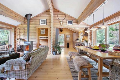 a living room with wooden walls and a table and chairs at Log Cabin Near Mariager Fjord in Hadsund