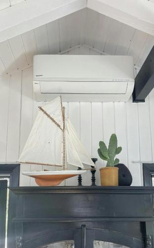 a model boat on top of a shelf with a plant at Summerhouse With Hot Tub On Langeland in Tranekær