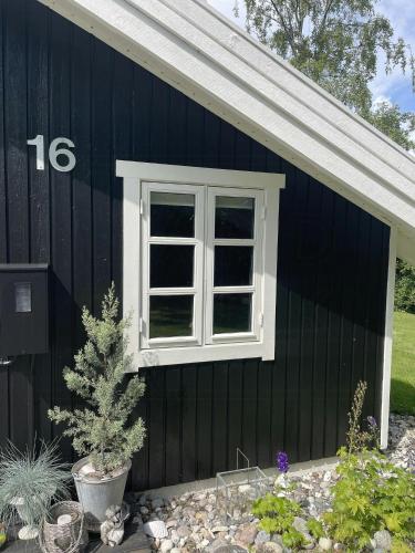 a black house with a window on the side of it at Summerhouse With Hot Tub On Langeland in Tranekær
