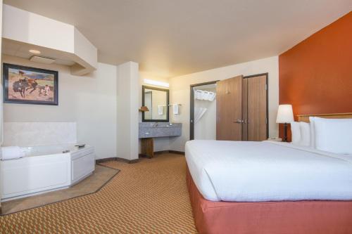 a hotel room with a bed and a bathroom at AmericInn by Wyndham Pampa Event Center in Pampa