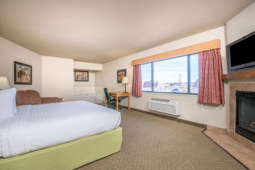 a hotel room with a bed and a fireplace at AmericInn by Wyndham Pampa Event Center in Pampa