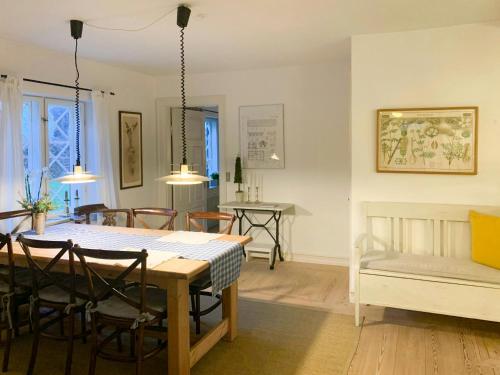 a dining room and living room with a table and chairs at Historic Gamekeepers House At Tranekær Castle in Tranekær