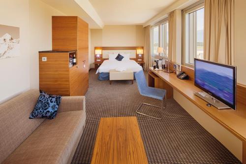 a hotel room with a bed and a television at Mövenpick Hotel Geneva in Geneva