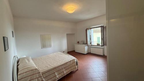 a bedroom with a bed and a window at La Casa in Piazza in Serre di Rapolano