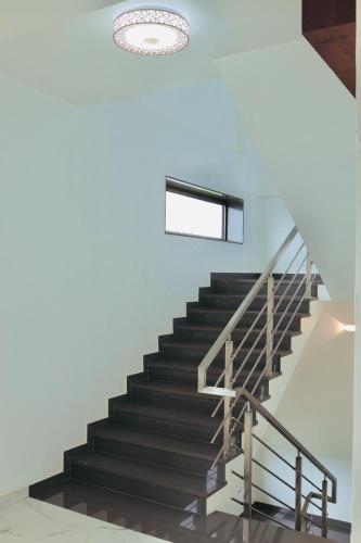 a staircase in a house with a chandelier at Hotel Laxmi Elite Karad in Karad