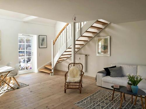 a living room with a staircase and a couch at Historic Farm Atmosphere In Tisvildeleje in Tisvilde