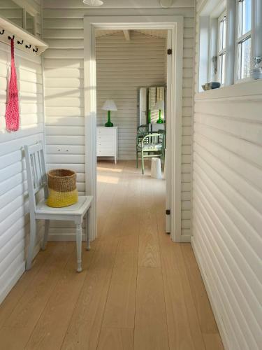 a hallway with a chair and a room with a table at Cozy Summer House In Rørvig With Historical Charm in Rørvig