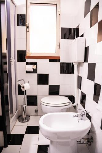 a black and white bathroom with a toilet and a sink at Casa Josto a due passi da Spiaggia Maladroxia in Maladroxia