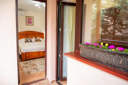 a bedroom with a bed and a window with flowers at Complex Koko Hills in Sapareva Banya