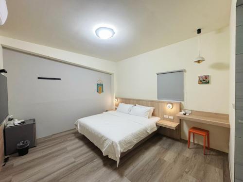 a bedroom with a white bed and a flat screen tv at 海洋星空民宿 in Magong