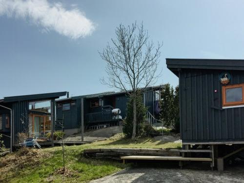 a row of houses with a tree and a bench at Family-Friendly Cabin South Of Oslo in Tjøme