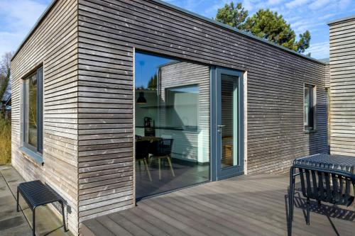 ein Haus mit Glasschiebetüren auf einer Terrasse in der Unterkunft Light Flooded Holiday House On The Baltic Sea in Ahrenshoop