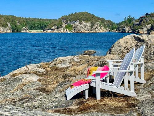 two chairs sitting on the rocks near the water at Irresistible Cabin Gem In Hvaler in Hauge