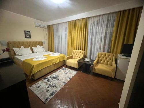 a hotel room with a bed and two chairs at Hotel Vera in Eforie Nord