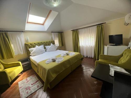 a bedroom with a large bed and two chairs at Hotel Vera in Eforie Nord