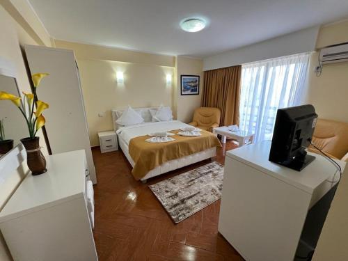 a hotel room with a bed and a television at Hotel Vera in Eforie Nord