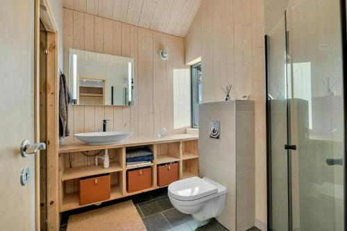 a bathroom with a toilet and a sink and a shower at Modern Cabin In Harmony With Nature in Moen i Målselv
