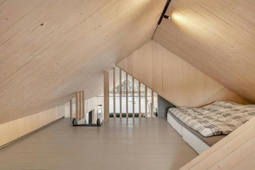 an attic bedroom with a bed and a window at Modern Cabin In Harmony With Nature in Moen i Målselv