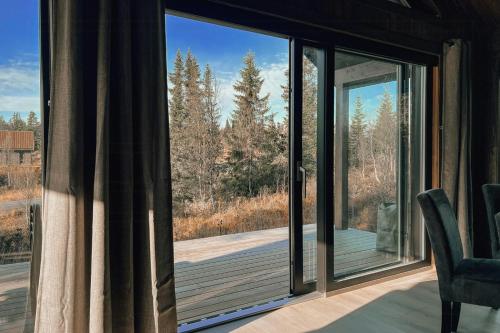 a room with a sliding glass door looking out onto a deck at Modern Mountain Cabin Near Syningtoppen in Torpo