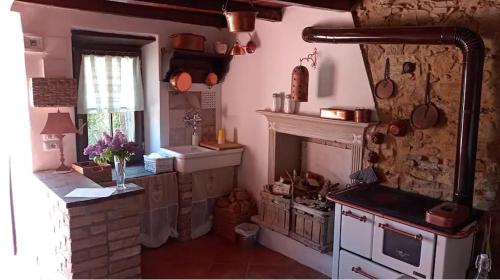 a kitchen with a stove and a fireplace at C'ERA UNA VOLTA... in Mornico Losana