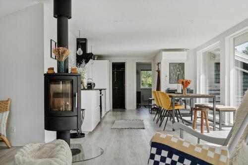 a living room with a stove and a table at Beautiful Tranquil Home By Fjord Near Copenhagen in Holbæk