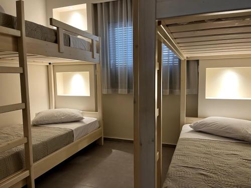 a bedroom with two bunk beds and a window at The 52 Spot in Kos Town