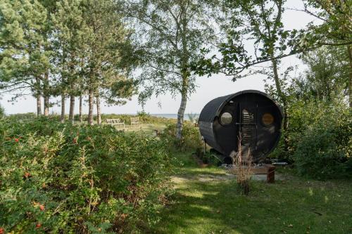 a boat sitting in the grass near some trees at Modern Exclusivity In 60S House Near Dyngby Beach in Odder