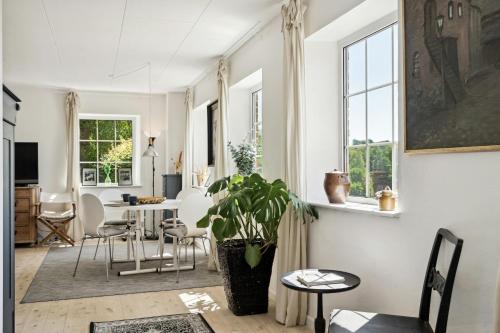 a living room with a table and chairs and a plant at Holiday Apartment On Hærvejen In Dollerup Hills in Viborg
