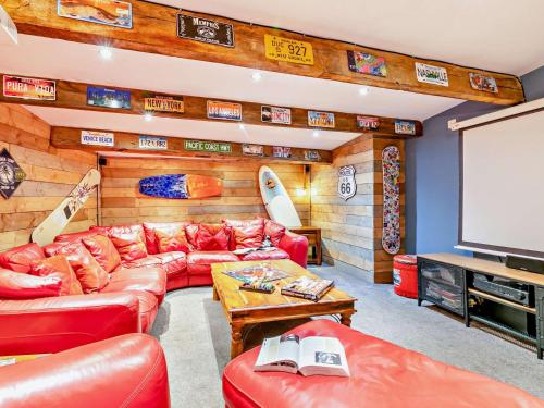 a living room with a red couch and a screen at 6 Bed in Slaithwaite 93984 in Huddersfield
