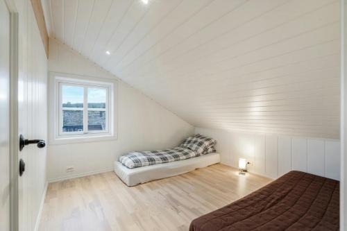 a attic bedroom with a bed and a window at High-Standard Cabin In Beautiful Rauland in Rauland