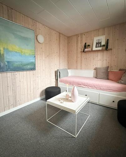ヒュールスミンネにあるBeach Summerhouse In Juelsmindeのベッドとテーブルのあるリビングルーム