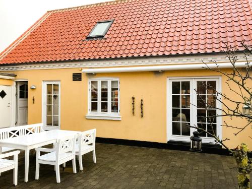 a yellow house with a white table and chairs at Live In Classic Skagen House In Skagen's Heart in Skagen