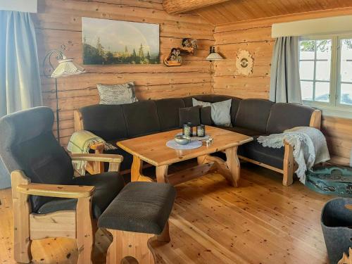 a living room with a couch and a table at Cozy, Magical Mountain Cabin With Trails in Etnedal