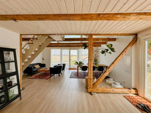 an open living room with wooden ceilings and a living room at Modern Apartment On Historic Horse Farm in Jonstorp