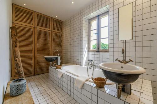 une salle de bain avec une baignoire et un lavabo dans l'établissement Historic Estate Overlooking The Dordogne, à Castelnaud-la-Chapelle